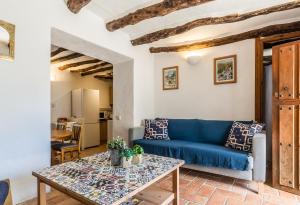 ein Wohnzimmer mit einem blauen Sofa und einem Tisch in der Unterkunft Casa Mundo - 16th century traditional white village house with pool in Pinos del Valle