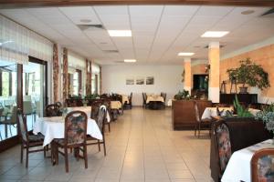 een eetkamer met tafels en stoelen in een restaurant bij Hotel Waldschlösschen in Dankmarshausen