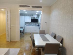 een eetkamer met een tafel en stoelen en een keuken bij Abmasador Apartment in Baku