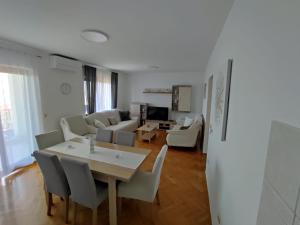 a dining room and living room with a table and chairs at House Silva in Podstrana