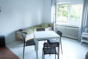 Cette chambre comprend une table, des chaises et un lit. dans l'établissement Ferienwohnung mit TV und WLAN, à Remscheid