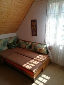 un sofá en una habitación con ventana en Holiday House Retro, en Szántód