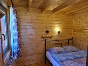 a bedroom in a log cabin with a bed in it at Siedlisko nr 5A nad jeziorem Skarlińskim, jezioro, mazury, domki letniskowe, bania in Kurzętnik
