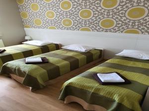 two beds sitting next to each other in a room at Hotel Klidzina in Skrīveri