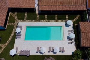 - une vue sur la piscine et ses chaises dans l'établissement La Corte Di Pulicinu, à Baja Sardinia