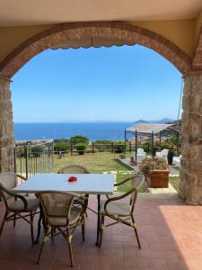 a table and chairs on a patio with a view of the ocean at Villa Alba in Marciana Marina