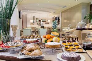 a buffet filled with different types of cakes and pastries at Erbavoglio Hotel in Rimini