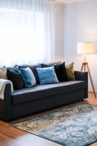 un sofá en la sala de estar con almohadas azules en Õhtu Põik 2 City Center basement Apartment, en Pärnu
