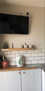 a kitchen counter with a microwave and a tea kettle at The Stables self catering in Seahouses