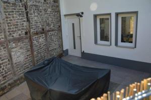 a black tarp on a room with a brick wall at Ganze Wohnung - schönes und helles Loft in Kreuzau in Kreuzau