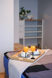 una bandeja con dos vasos de zumo de naranja en una mesa en Õhtu Põik 2 City Center basement Apartment, en Pärnu