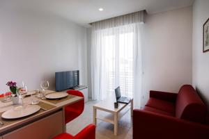 een woonkamer met rode stoelen en een bureau met een laptop bij Casa Plauto in Bellaria-Igea Marina