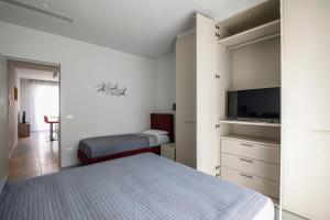 een slaapkamer met een bed en een flatscreen-tv bij Casa Plauto in Bellaria-Igea Marina
