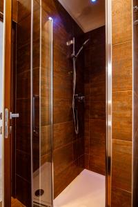 een douche met houten wanden en een glazen deur bij Casa Plauto in Bellaria-Igea Marina