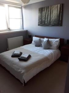 a bedroom with a bed with two towels on it at Aberdeen Quiet City Apartment, Ferryhill in Aberdeen