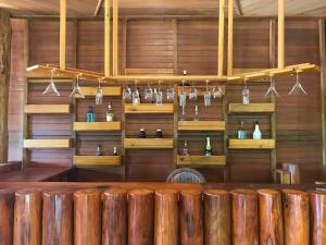 a restaurant with wooden walls and a bar with glasses at Gibbon Lodge in Senmonorom