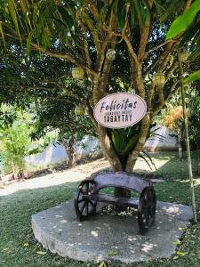 a sign on a bench in front of a tree at Felicitas Tagaytay in Tagaytay
