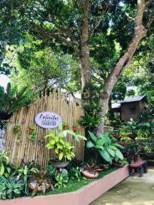 a garden with plants and a fence with a sign at Felicitas Tagaytay in Tagaytay