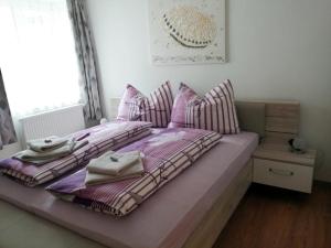 ein Bett mit Kissen und Handtüchern darauf in einem Schlafzimmer in der Unterkunft Wohlfühlhof Bachzelt in Weitersfeld
