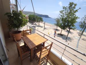 einen Balkon mit einem Tisch und Stühlen sowie Strandblick in der Unterkunft Apartments Himara Premium in Himarë