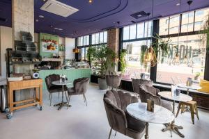 a restaurant with tables and chairs and windows at Hotel Haarhuis in Arnhem