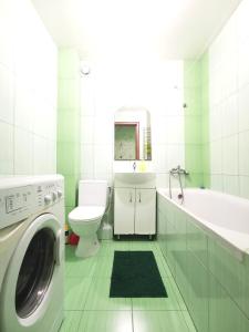 a white bathroom with a washing machine in it at Kakadu apartments in Sumy