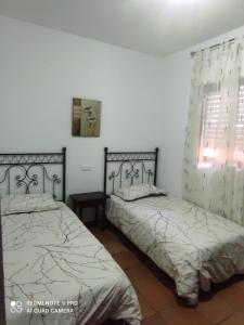 1 Schlafzimmer mit 2 Betten und einem Fenster in der Unterkunft Casa del Poniente in Lepe