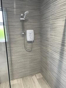 a shower with a shower head in a bathroom at Ketty's Cottage in Rosslea