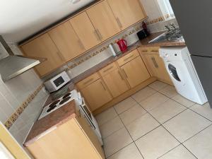 eine kleine Küche mit Holzschränken und einer Waschmaschine und einem Trockner in der Unterkunft Sweetpea Cottage - Sleeps 5 Parking & Pets Ok in Louth