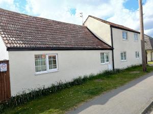 uma casa branca com um telhado castanho numa rua em Sweetpea Cottage in Louth em Louth