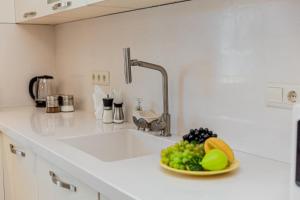 a kitchen sink with a bowl of fruit on it at Dat Exx Apartments On Liberty Square in Tbilisi City