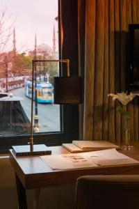 a desk with a lamp and a window with a bus at Boutique Saint Sophia in Istanbul