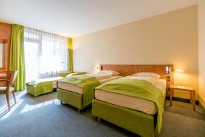 Postel nebo postele na pokoji v ubytování Schlosspark Hotel