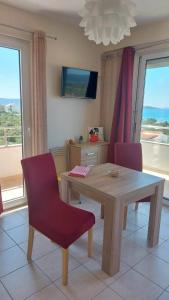a dining room with a wooden table and a red chair at Apartment Ruby in Šibenik +49 photos