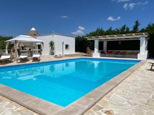 una grande piscina con gazebo di Trullo SERENDIPITY ad Alberobello