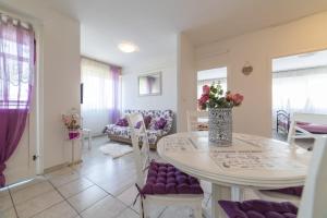 een woonkamer met een witte tafel en paarse stoelen bij Strawberry in Split