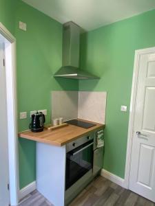 a small kitchen with green walls and a counter top at The Black Swan Hotel in Scarborough