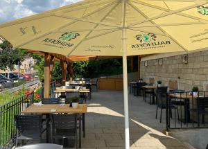 a restaurant with tables and chairs under a yellow umbrella at Hotel Heiligenstein in Baden-Baden