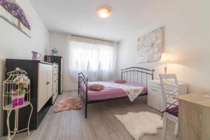 een kleine slaapkamer met een bed en een dressoir bij Strawberry in Split