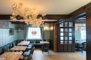 a restaurant with a chandelier and tables and chairs at Hotel Heiligenstein in Baden-Baden