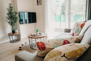 ein Wohnzimmer mit einem Sofa und einem TV in der Unterkunft Charmant appartement 4 étoiles Bella Vita Zen in Aix-les-Bains