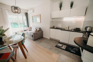 eine Küche und ein Wohnzimmer mit einem Tisch und einem Sofa in der Unterkunft Charmant appartement 4 étoiles Bella Vita Zen in Aix-les-Bains