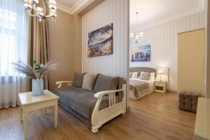ein Wohnzimmer mit einem Sofa und einem Bett in der Unterkunft Royal mini-apart hotel on Rynok Square in Lwiw