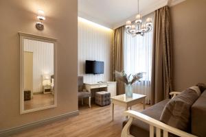 - un salon avec un canapé et un miroir dans l'établissement Royal mini-apart hotel on Rynok Square, à Lviv