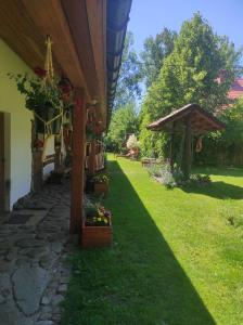 a garden with a house with a wooden umbrella at Święty Spokój in Tuchlin