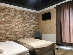 Un dormitorio con una pared de ladrillo y una cama en Bloom Hotel en Járkov