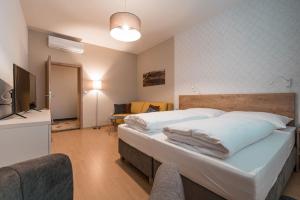 um quarto com uma cama grande e uma televisão em Penzion Jako Doma em Kyjov
