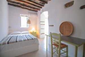 a bedroom with a bed and a desk and a chair at Traditional Villa in Ktikados - 3BR and SeaView in Khatzirádhos