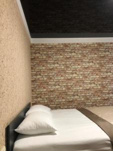 a bedroom with a brick wall and a bed at Bloom Hotel in Kharkiv