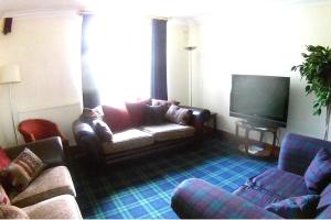 uma sala de estar com um sofá e uma televisão em Bimini House em Aberdeen